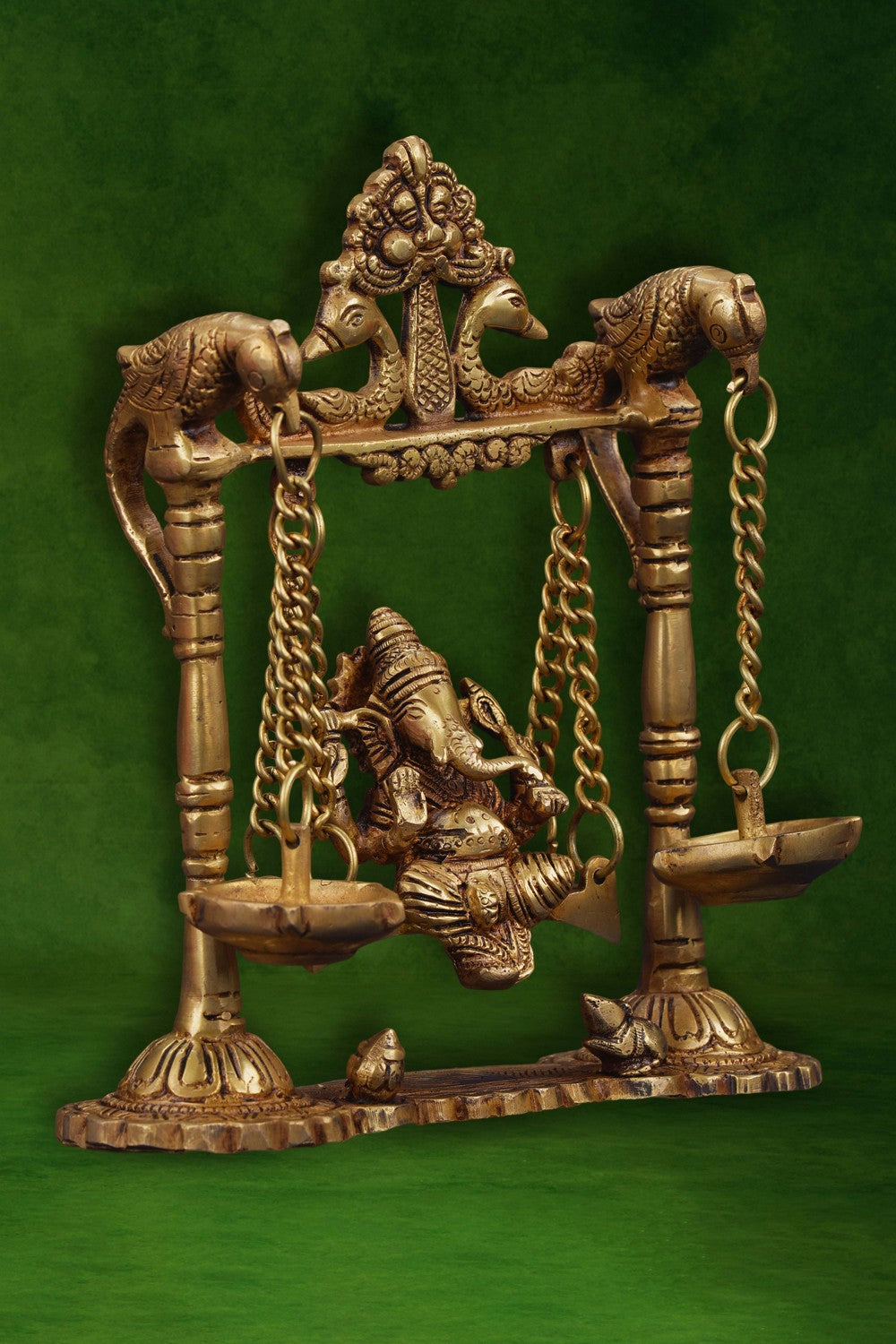 Image of Ganesh statue hanging a brass diya with peacocks