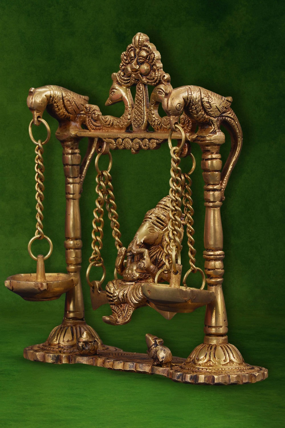 Image of Ganesh statue hanging a brass diya with peacocks