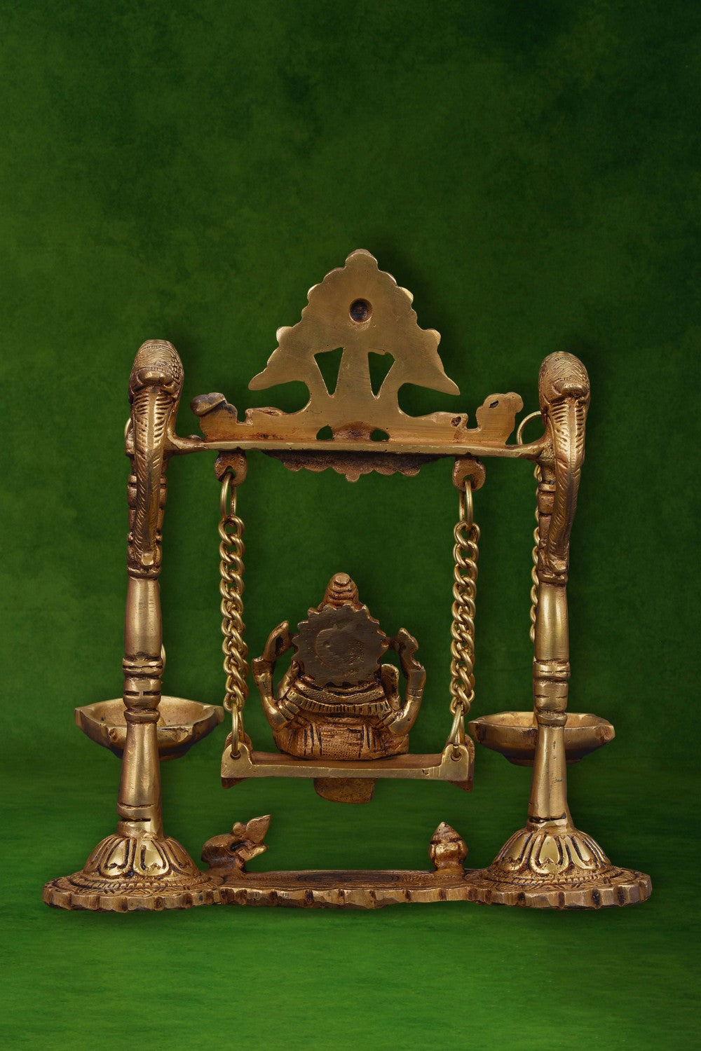 Image of Ganesh statue hanging a brass diya with peacocks