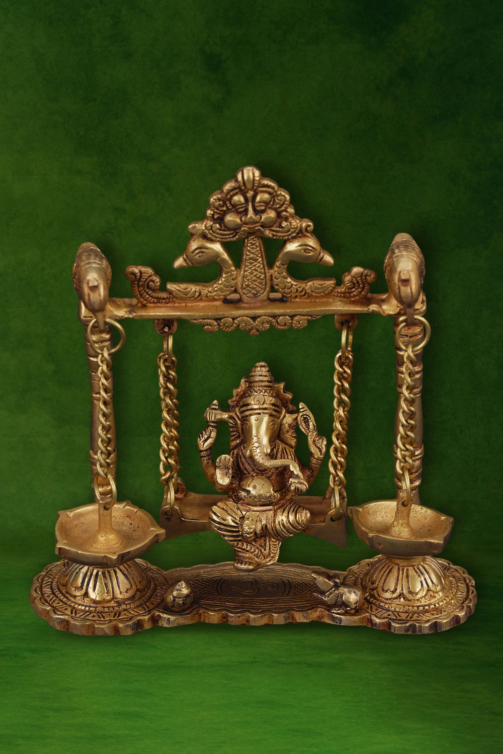 Image of Ganesh statue hanging a brass diya with peacocks