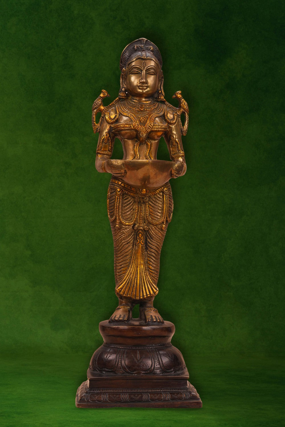 Image of A brass and copper woman holding a diya