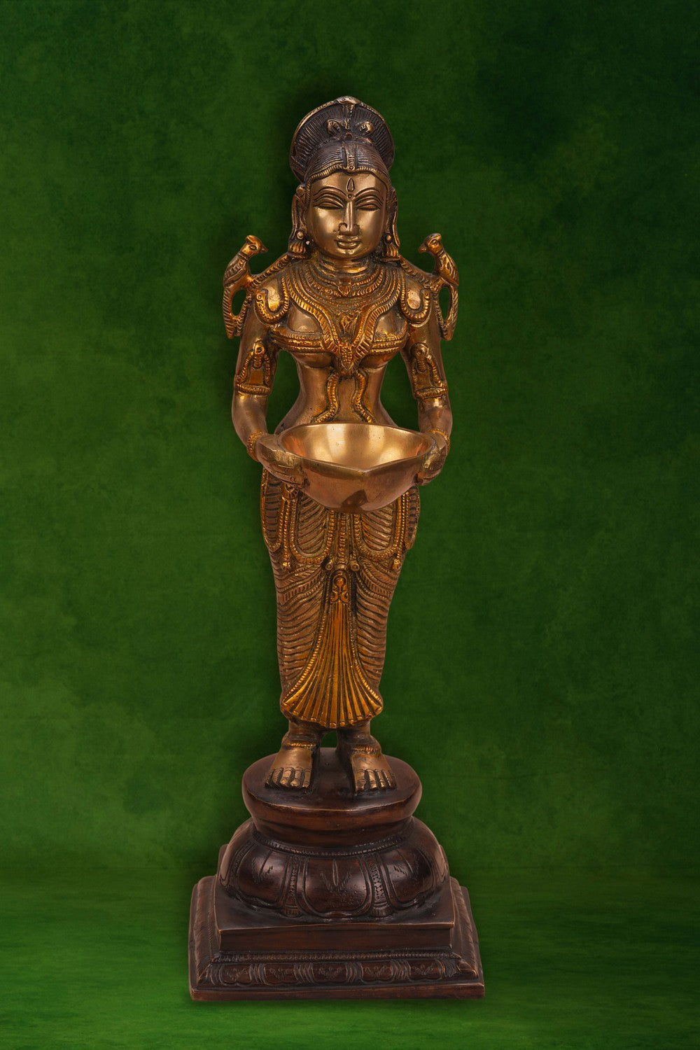 Image of A brass and copper woman holding a diya